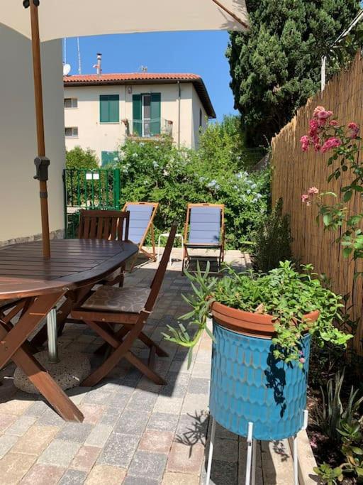 Patio con tavolo in legno e vasi blu fioriti