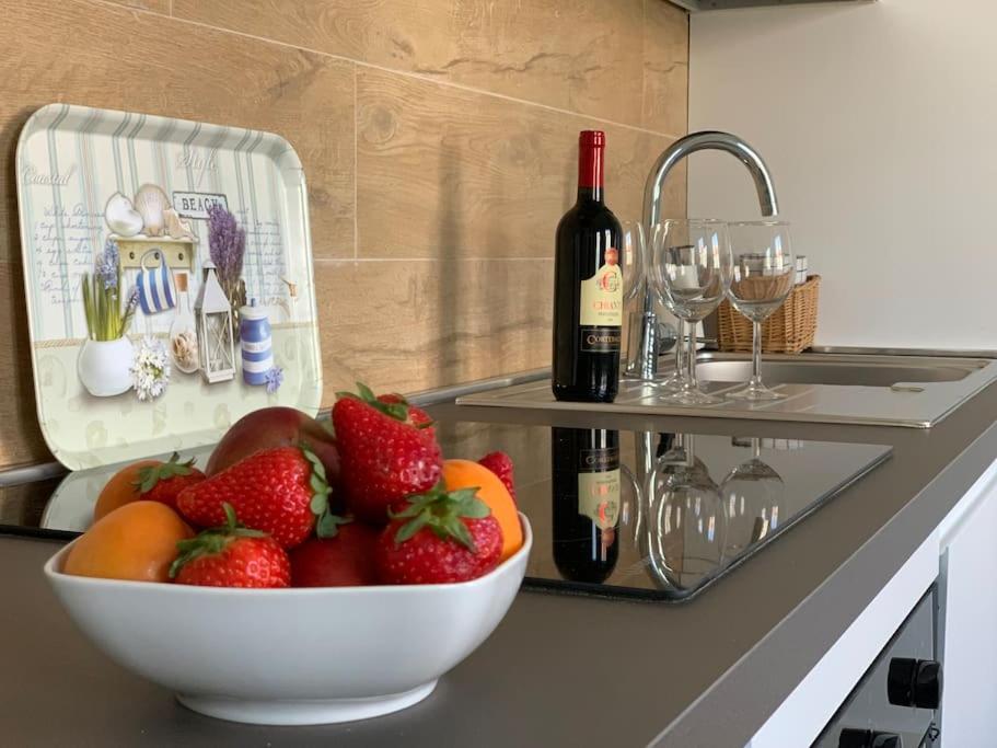 Piano cucina con ciotola di fragole, vino e bicchieri
