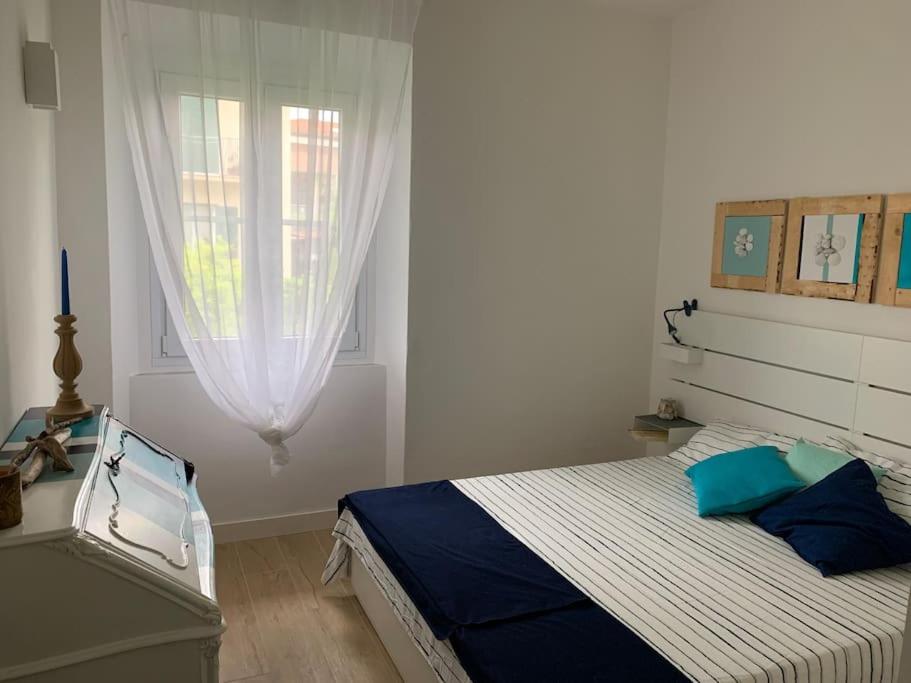 Camera da letto con tende bianche e quadri decorativi