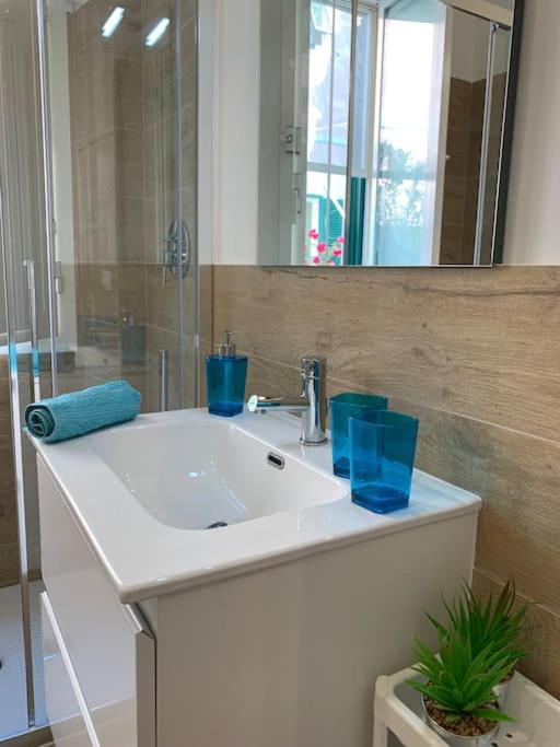 Bagno luminoso con lavabo, specchio e dettagli blu