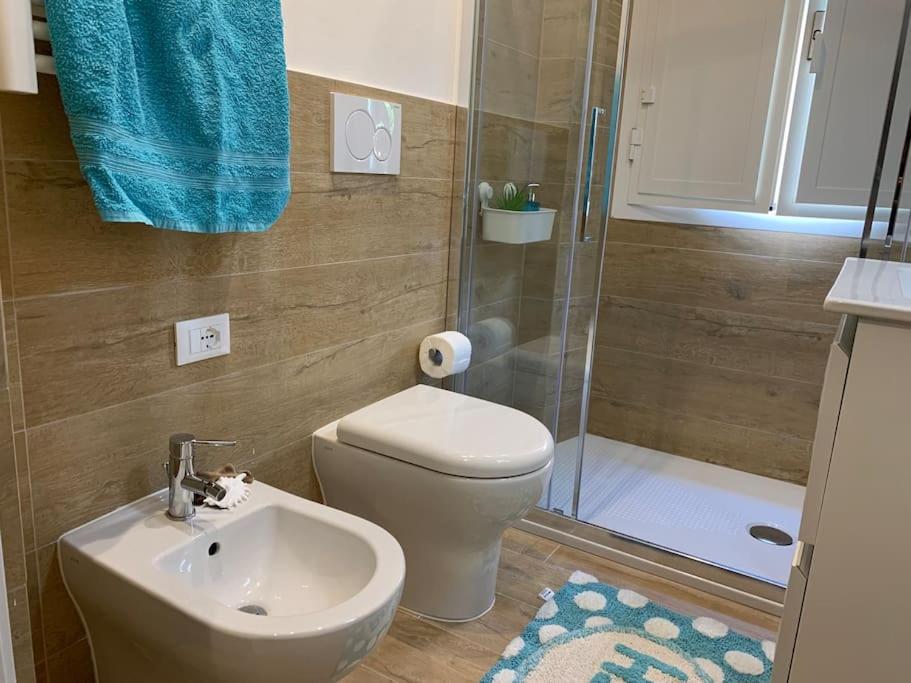Bagno con WC, bidet, doccia e asciugamano turchese