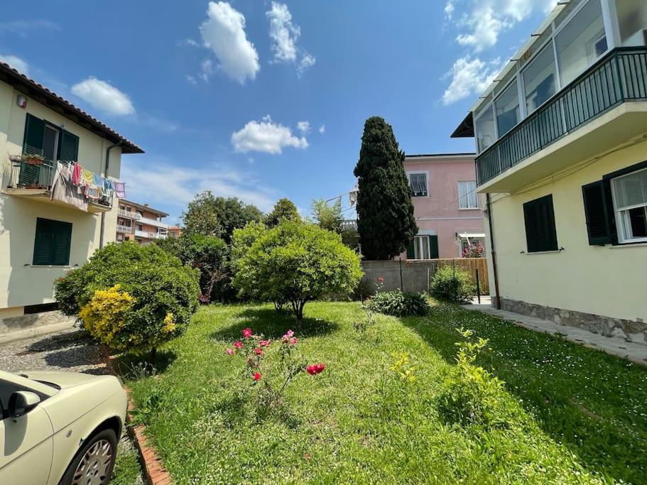 Giardino con prato verde, alberi e rose