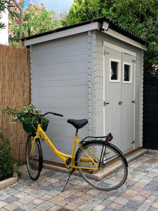 Bicicletta gialla Enjoy Toscana davanti alla casetta del giardino
